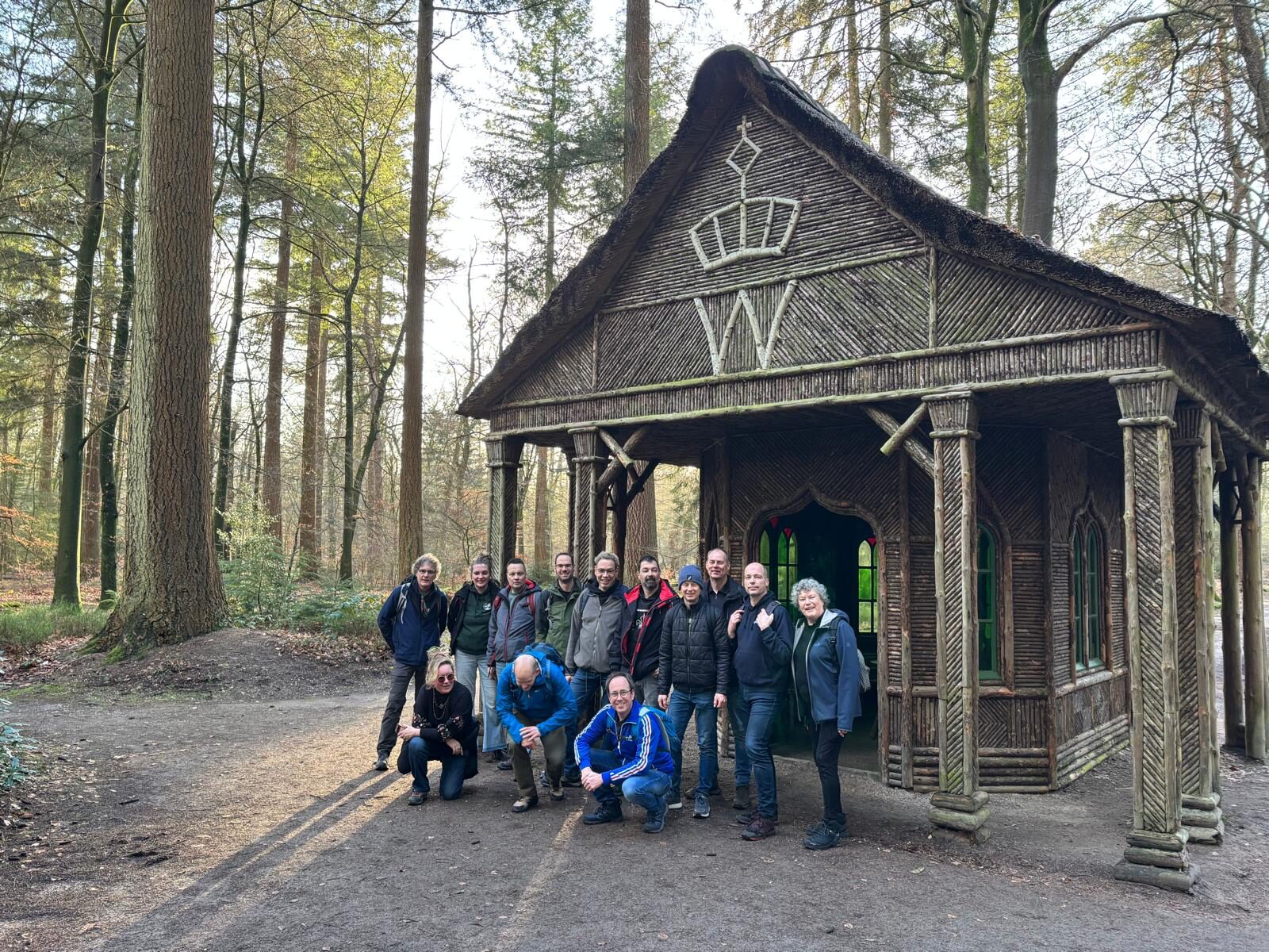 Groepsfoto van de Bokkenstam voor een houten hut in het bos